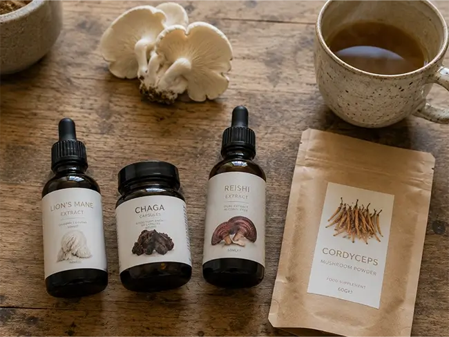 Lion's mane extract naast Cordyceps, Reishi en Chaga supplementen op houten tafel