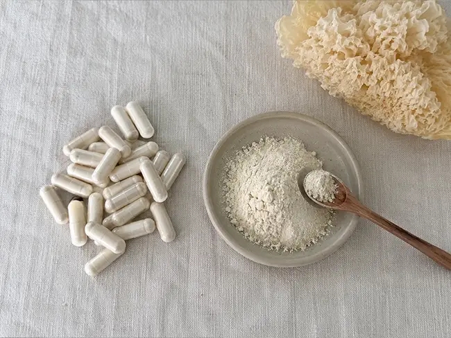 Snow Fungus Capsules naast een schaaltje tremella poeder ter vergelijking op een lichte tafel